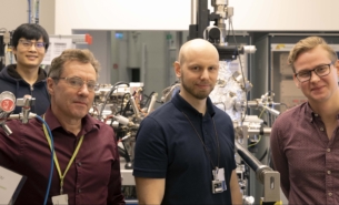 4 scientists posing for a photo in front of a beam line