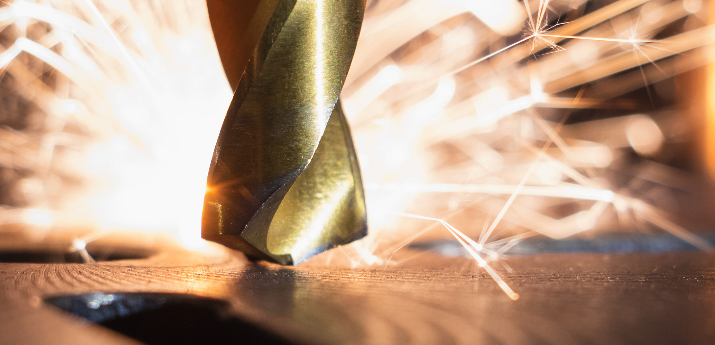 Picture showing a golden drill with sparks in the background