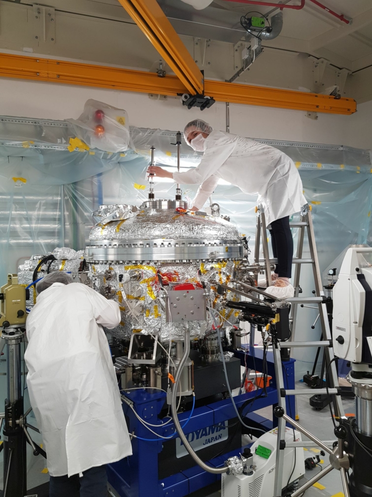 A woman working on a monochromator with a man in the foreground