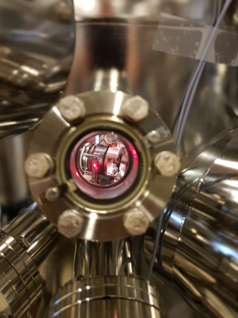 A laser shining through a window into a vacuum chamber