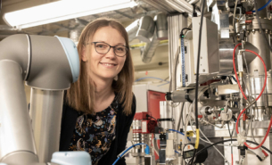 Woman looking from beyond a beamline station at MAX IV.