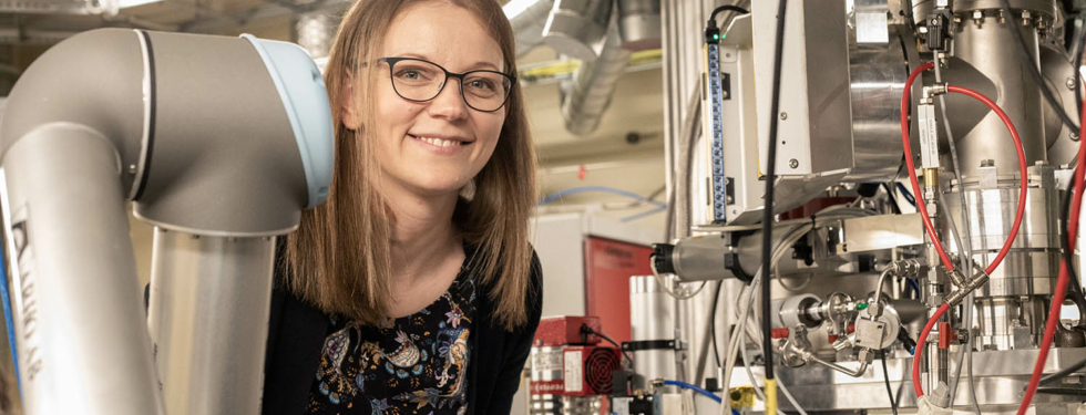 Woman looking from beyond a beamline station at MAX IV.