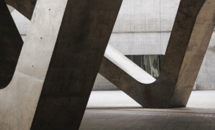 Grey concrete blocks in a concrete building with dark shadows.