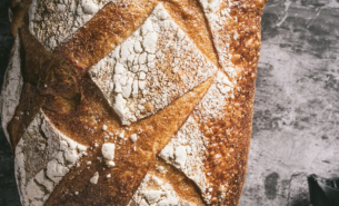 Close up image of freshly baked sourdough bread loaf on black and white background