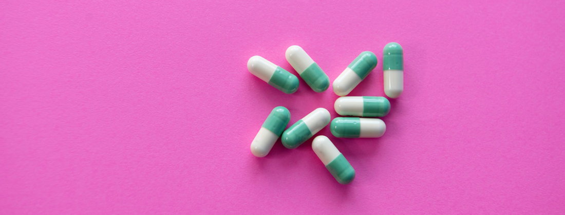 tablets pills green and white on pink background