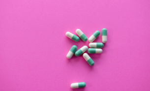 tablets pills green and white on pink background