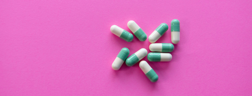 tablets pills green and white on pink background