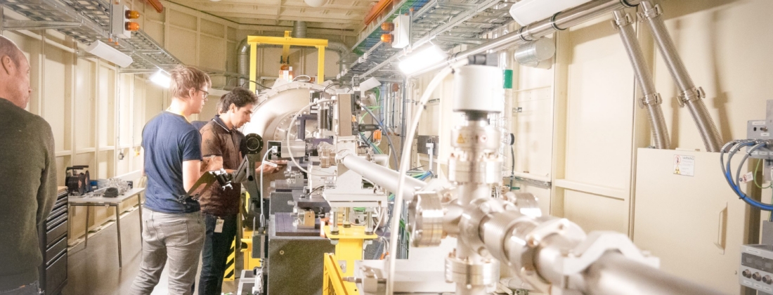 Two scientists examining a vacuum chamber during the first Formax experiments